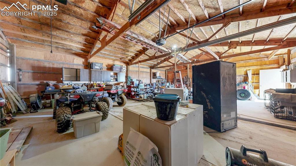 Image 36 of 40: Garage with a garage door opener and a workshop area