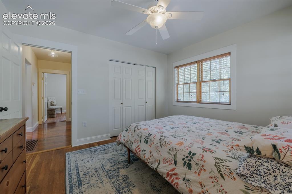 Image 14 of 49: Bright room featuring wood-finish flooring, a ceiling fan with integrated l