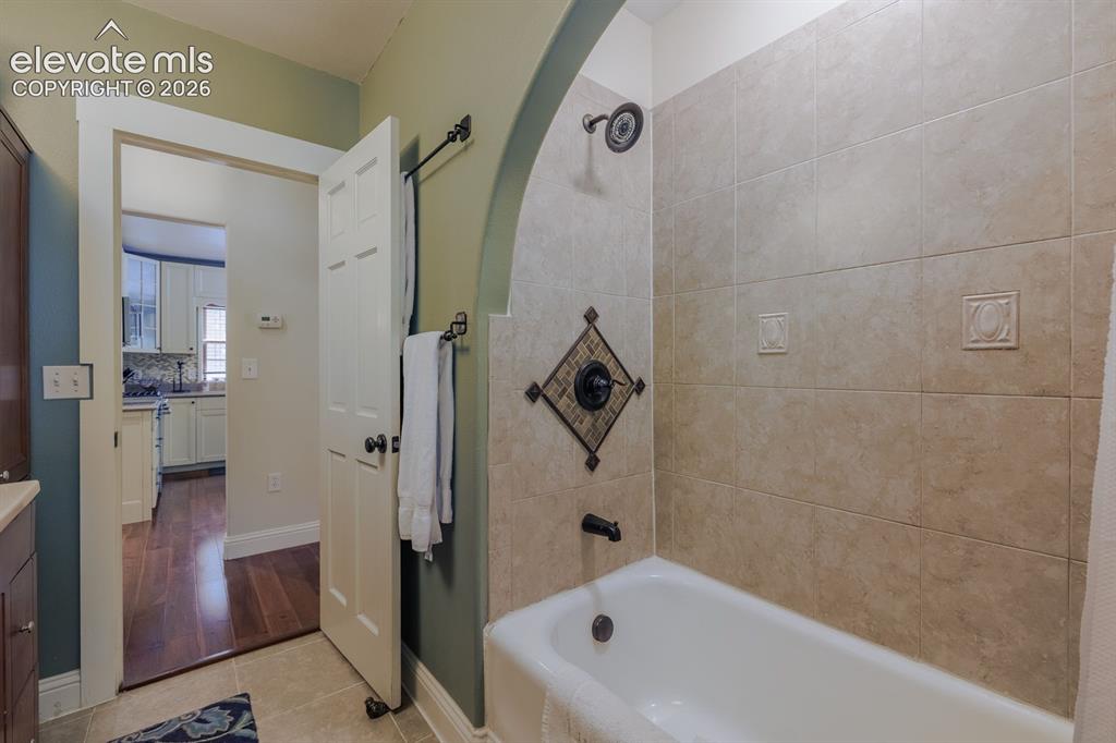 Image 16 of 49: Tile-surround bathtub with a decorative accent tile