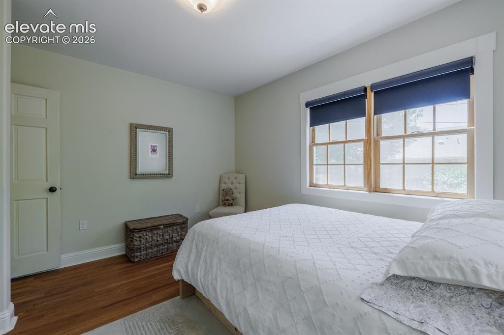 Image 18 of 49: Bedroom featuring wood-finish flooring, a two-panel interior door, and a do