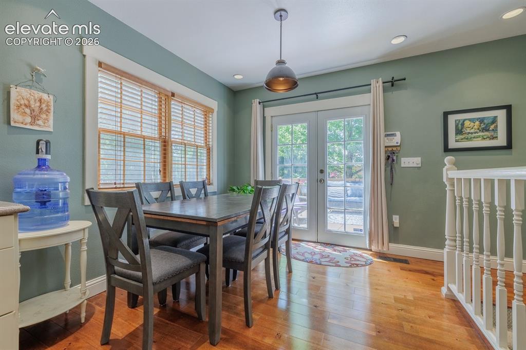 Image 19 of 49: Dining area featuring wood-finish flooring, a contemporary pendant light fi