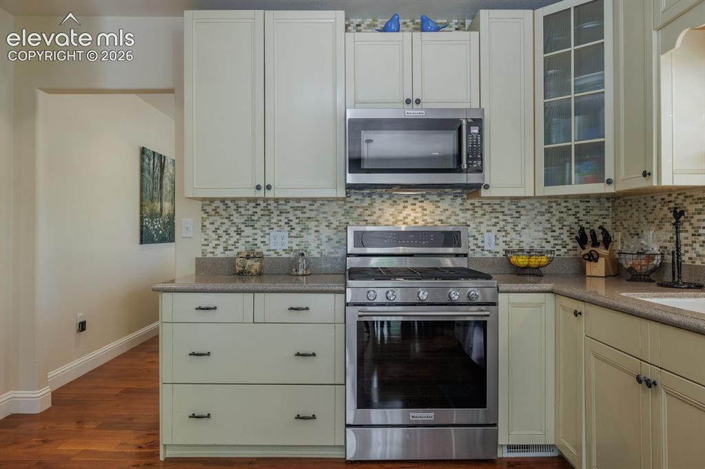 Image 22 of 49: Kitchen featuring stainless steel range with overhead microwave, light-tone
