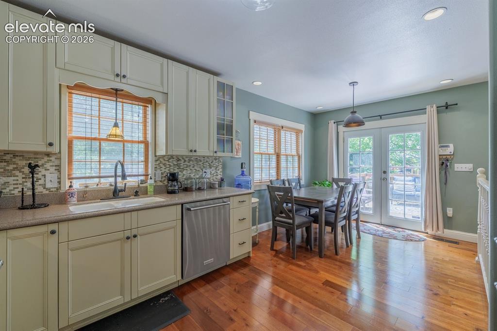Image 23 of 49: Kitchen featuring light-toned cabinetry, a mosaic tile backsplash, and a do