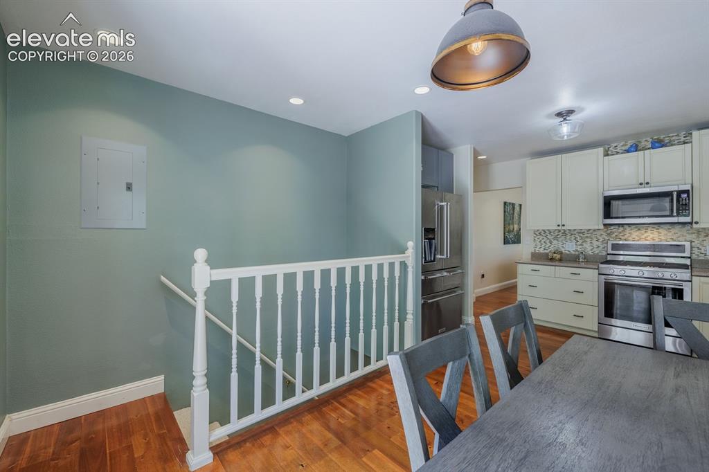 Image 27 of 49: Open-concept kitchen and dining area featuring warm wood-finish flooring, r