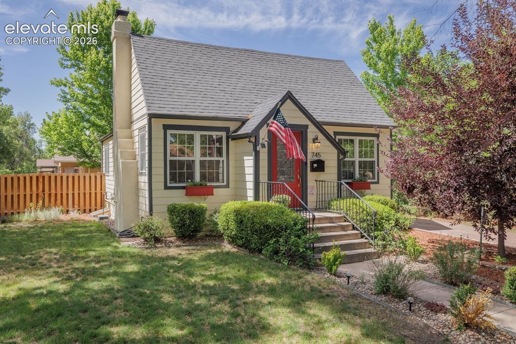Image 3 of 49: Charming cottage-style home featuring light yellow siding with dark trim ac