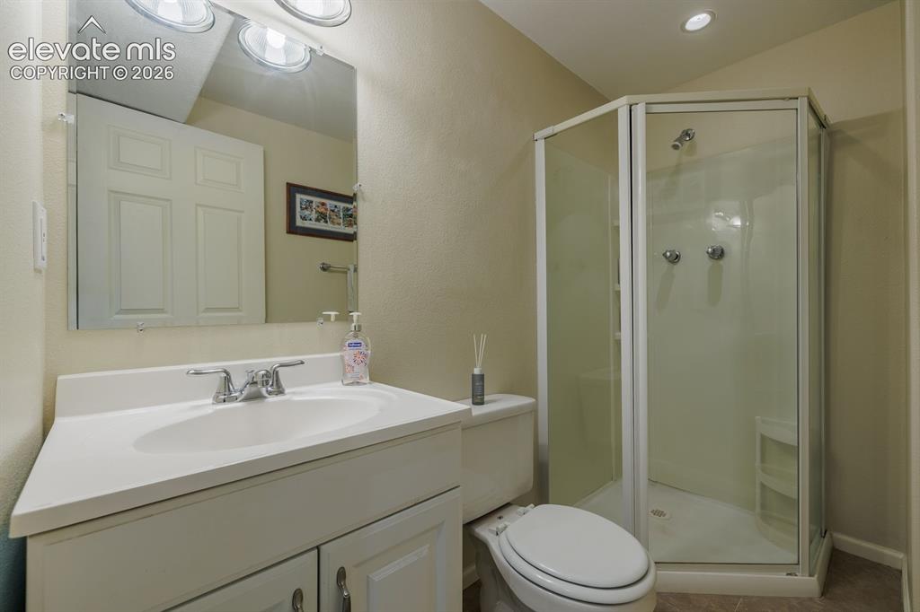 Image 31 of 49: Bathroom featuring a corner shower enclosure with frosted glass panels, a w