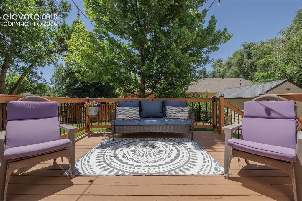 Image 35 of 49: Spacious wood-finish deck with a built-in railing, featuring a symmetrical
