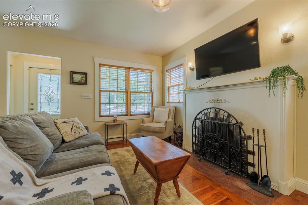 Image 9 of 49: Living area featuring wood-finish flooring, a decorative fireplace with an