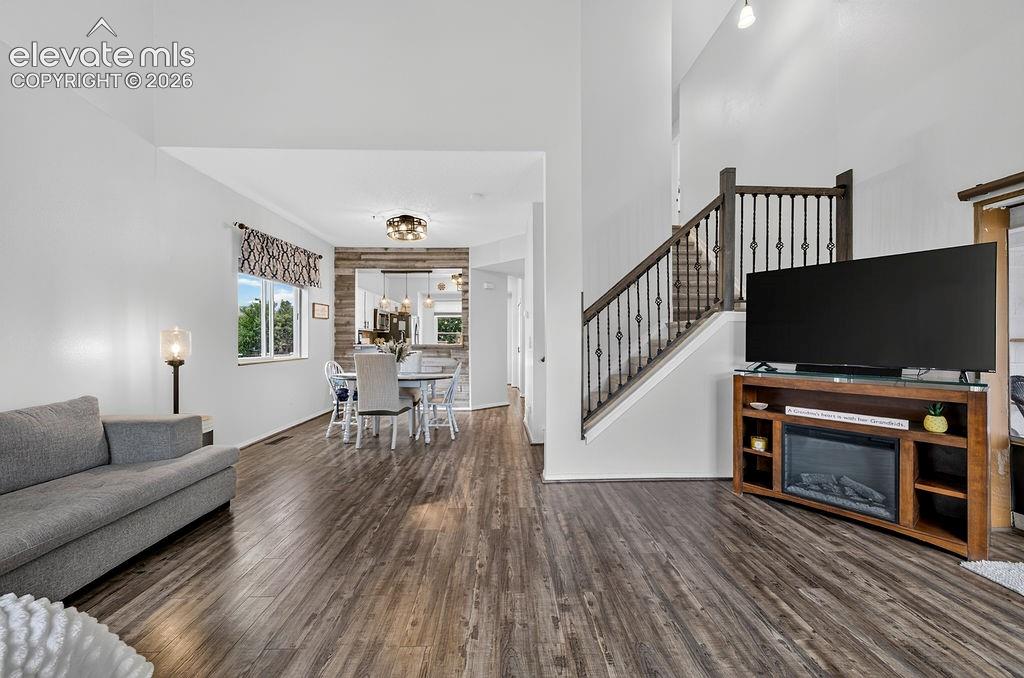Image 14 of 30: High vaulted ceilings, wood-finish flooring, staircase with dark wood banis