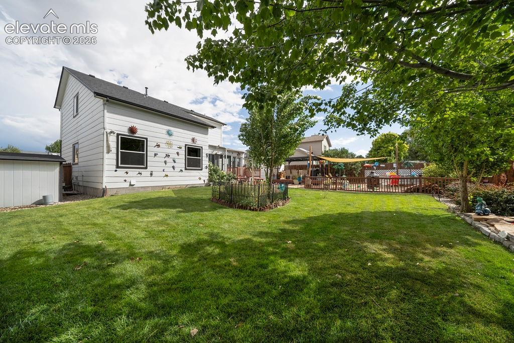 Image 2 of 30: Expansive lawn area with mature trees and a dedicated shed