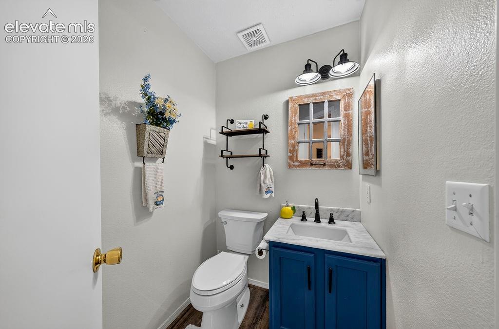 Image 23 of 30: Powder room featuring a blue vanity, a rectangular sink with a matte black 