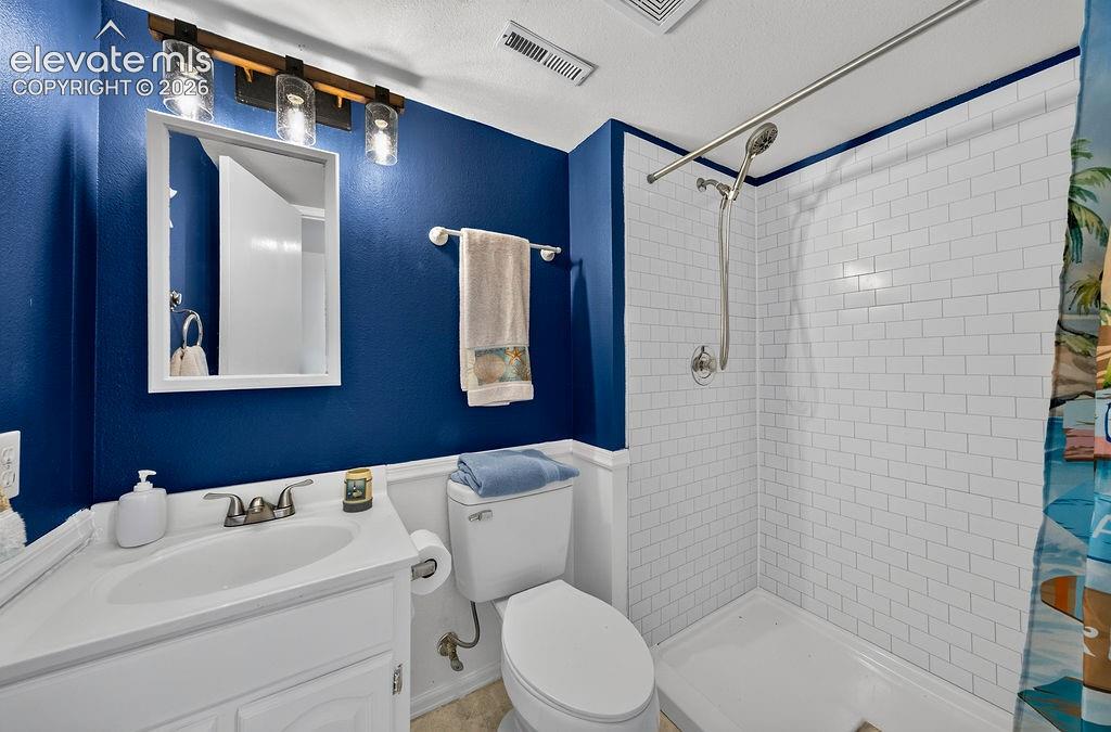 Image 24 of 30: White vanity with integrated sink, subway tile shower surround, chrome show