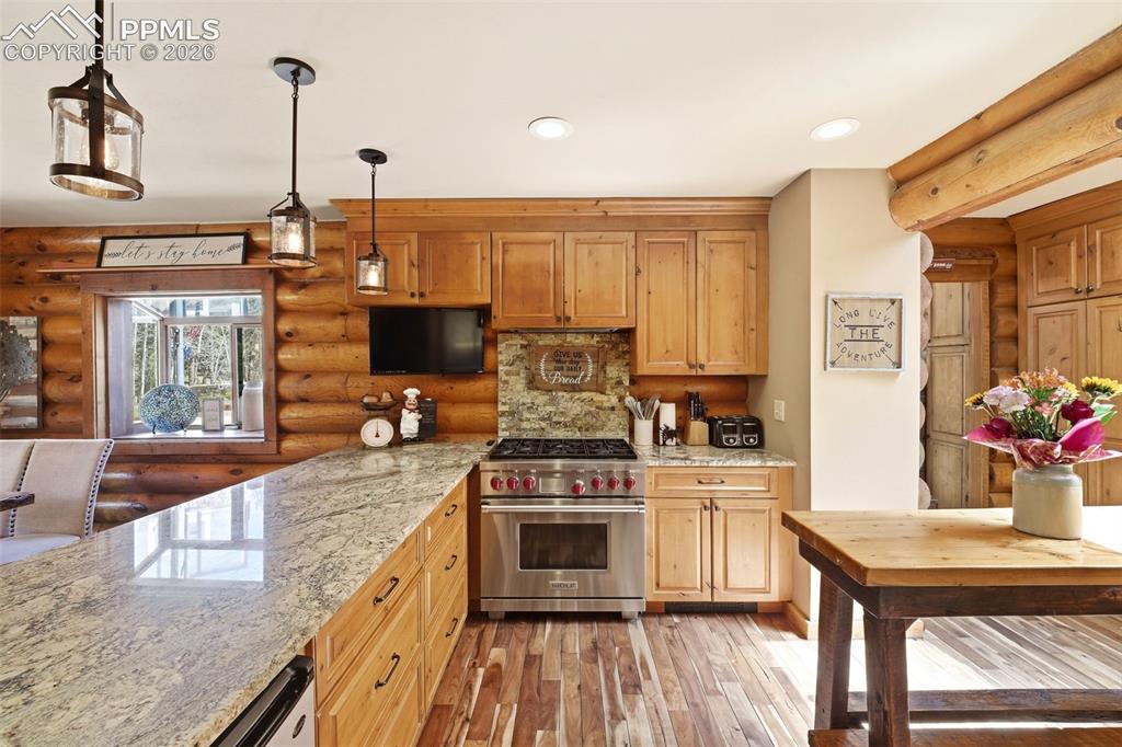 Image 11 of 50: Gourmet kitchen featuring a substantial granite island, custom wood cabinet