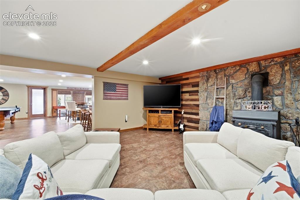 Image 26 of 49: Open-concept living area featuring exposed wood beams and recessed lighting