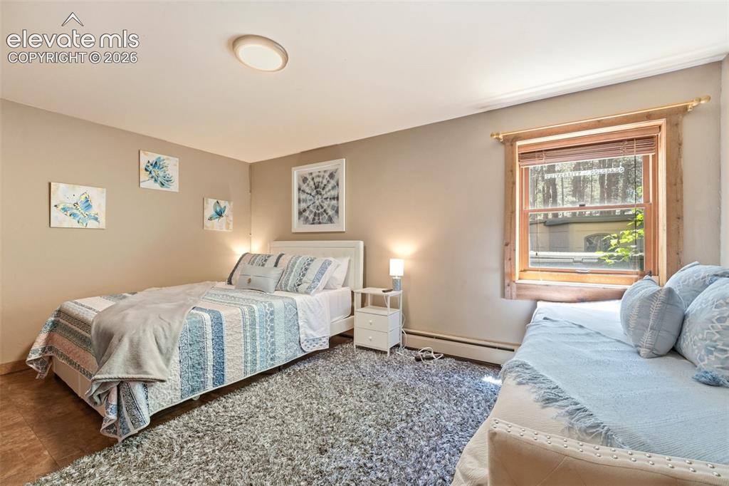 Image 30 of 49: Bedroom featuring light neutral wall paint and a wood-framed window with wo