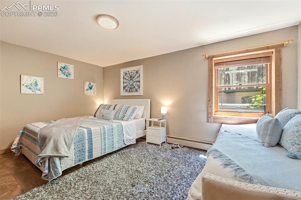Image 32 of 50: Bedroom featuring light neutral wall paint and a wood-framed window with wo