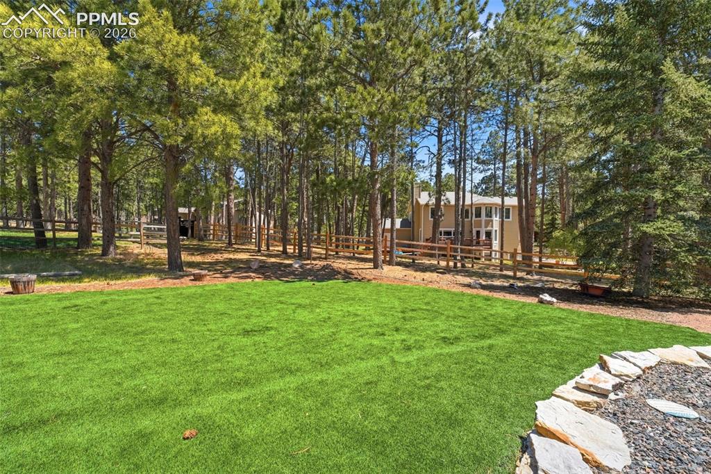 Image 47 of 50: Manicured lawn area with a stone-edged landscape feature