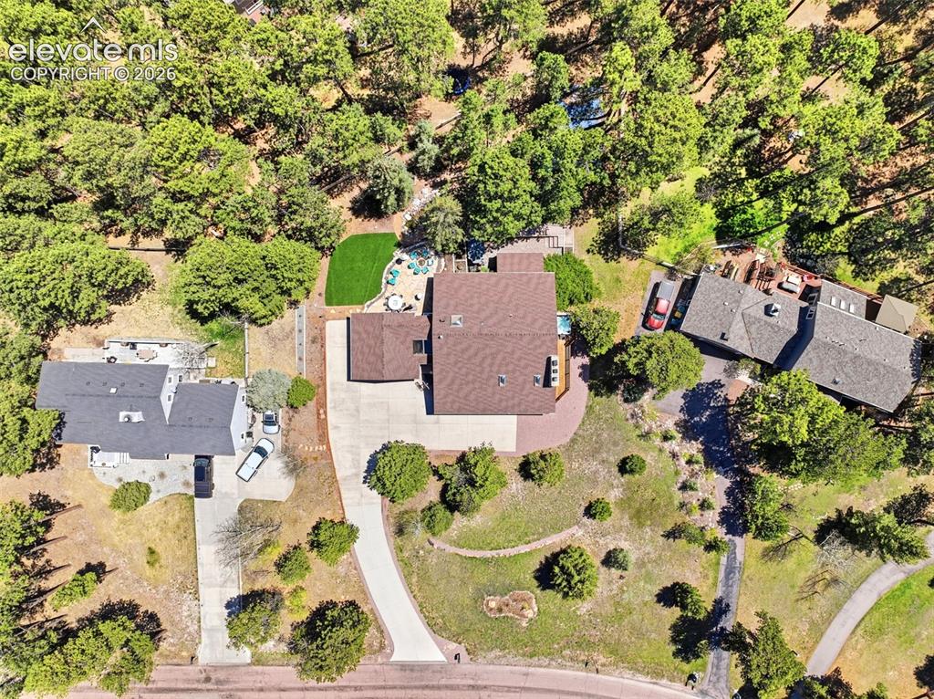 Image 47 of 49: Expansive property featuring a curved driveway, mature trees, a private dec