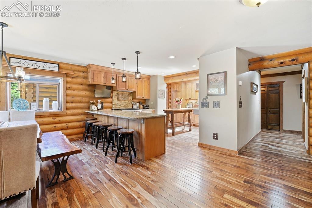 Image 6 of 49: Open-concept kitchen and dining area with wood-finish flooring