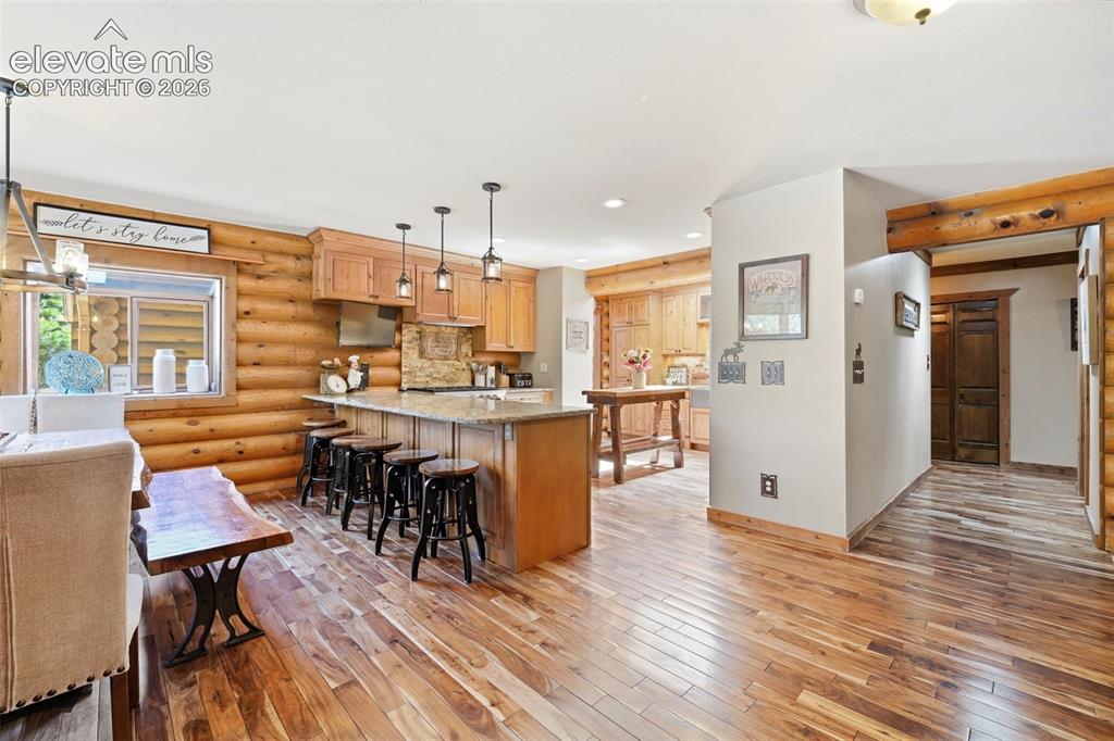Image 6 of 49: Open-concept kitchen and dining area with wood-finish flooring