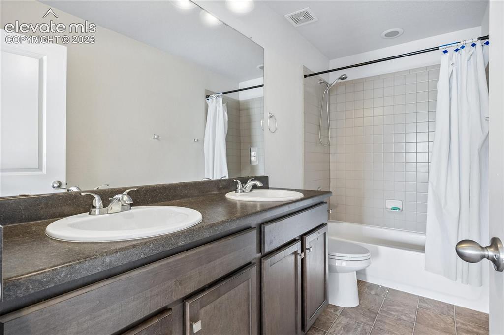 Image 16 of 39: Bedroom featuring light gray wall paint and one accent wall with a textured