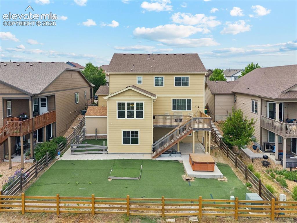 Image 33 of 39: Two-story residence featuring a covered front porch with white railing, sto