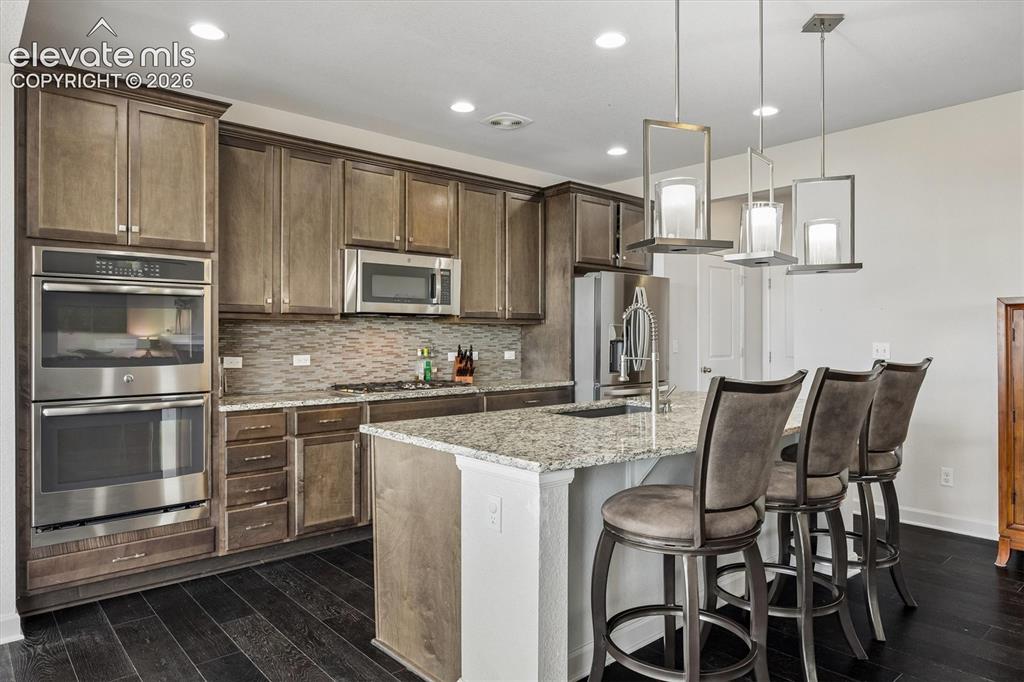 Image 4 of 39: Kitchen featuring dark wood-finish flooring and recessed lighting