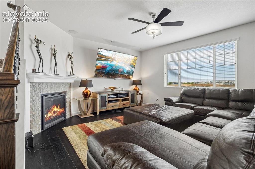 Image 6 of 39: Living area featuring a fireplace with a tiled surround and mantel