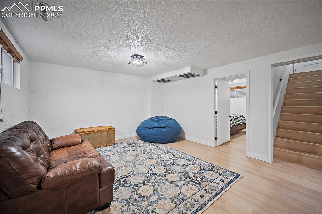 Image 23 of 44: Basement family room with laminate flooring. 