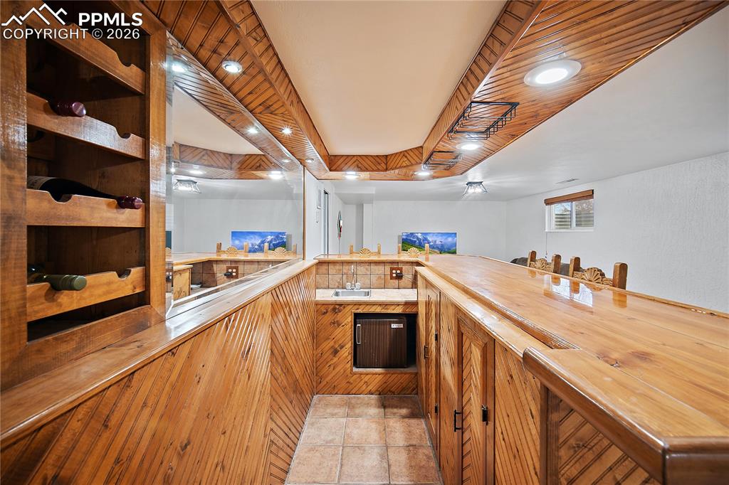 Image 25 of 44: Beautiful vintage bar with sink and mini fridge. 