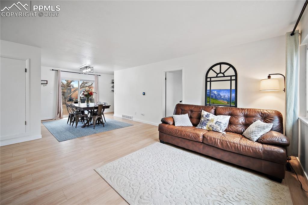 Image 4 of 44: Living room with laminate flooring. Open to the dining room. 