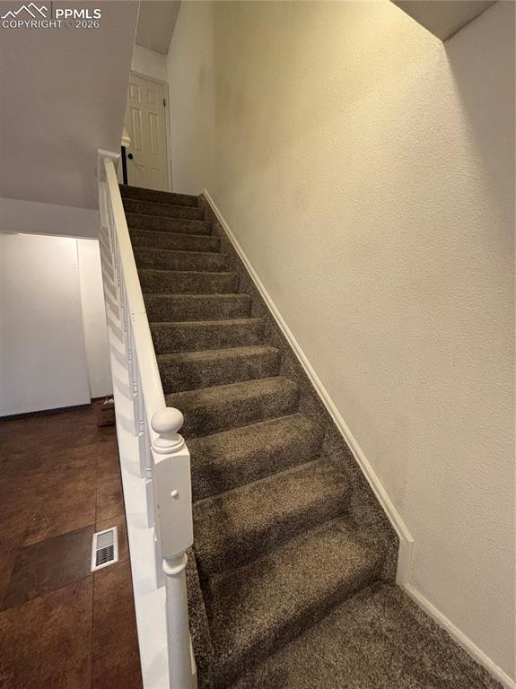 Image 10 of 34: stairs to upper level with primary suite