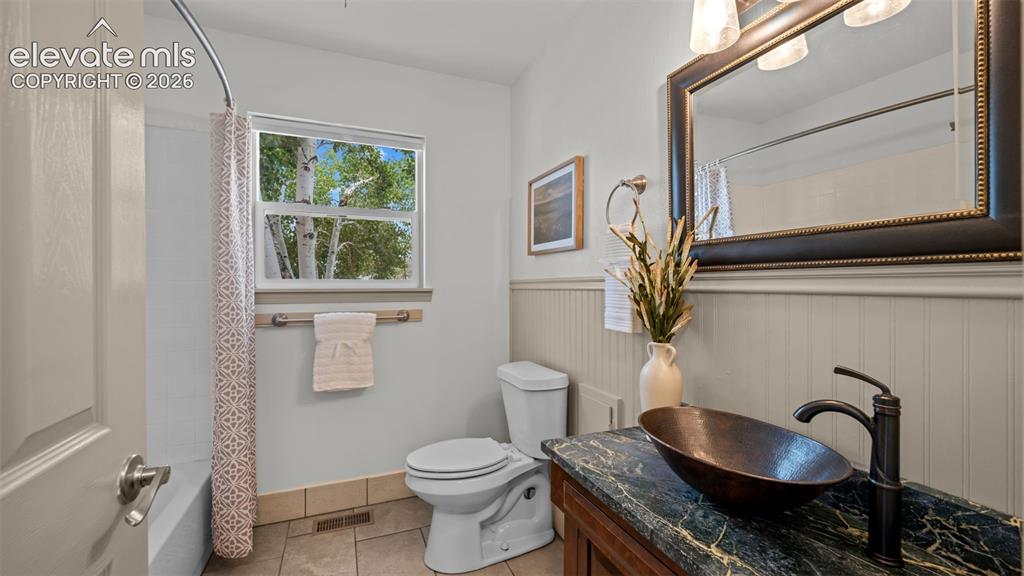 Image 7 of 45: Full bath right off the entry with a beautiful copper vessel sink!