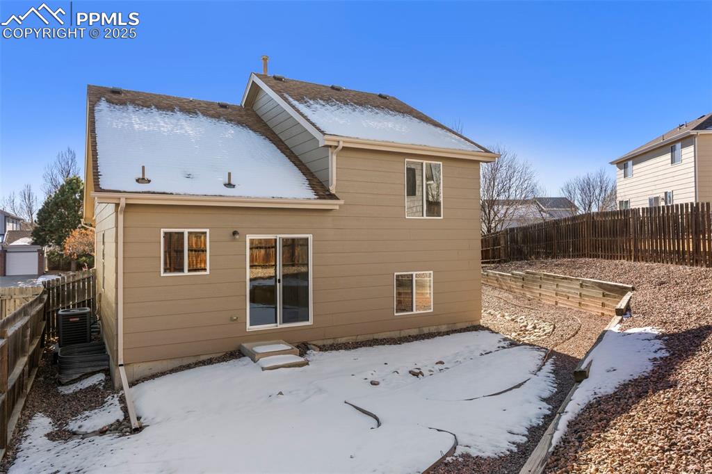 Image 24 of 25: Snow covered back of property with a fenced backyard