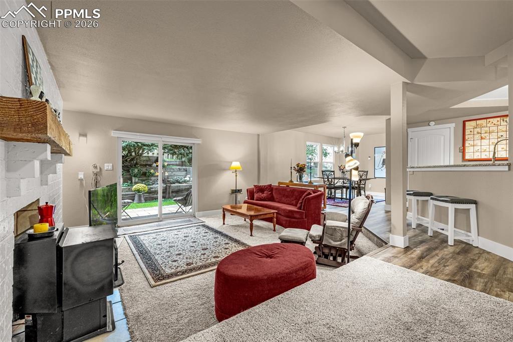 Image 10 of 21: Living room with a fireplace, a chandelier, and wood finished floors