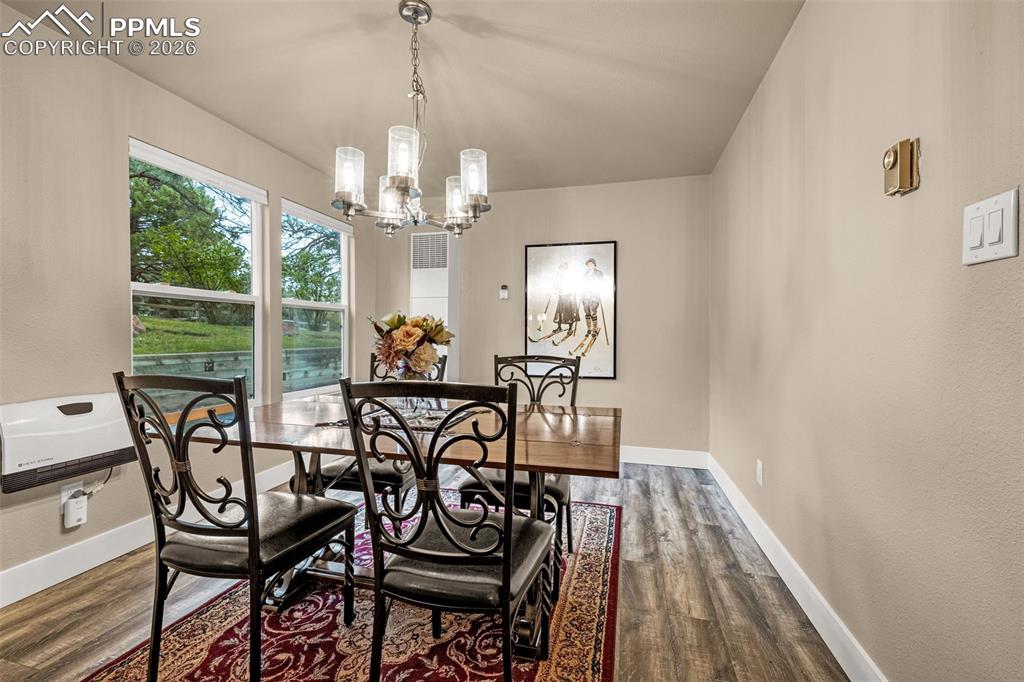 Image 12 of 21: Dining room with wood finished floors and a chandelier