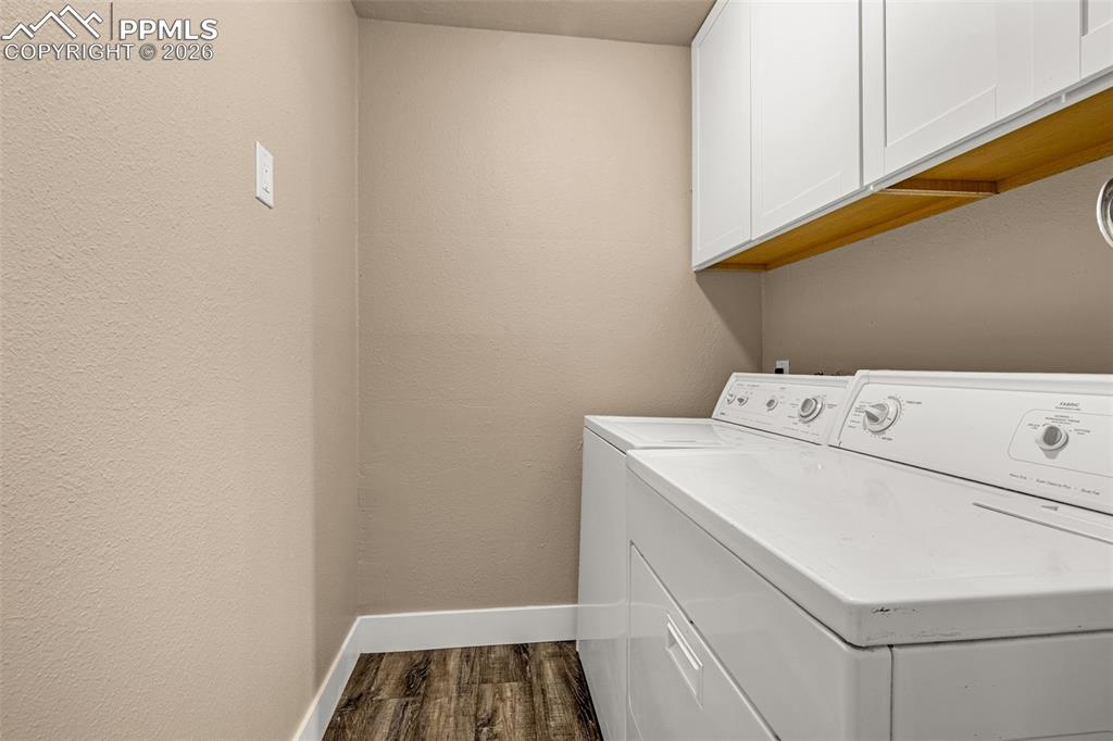 Image 16 of 21: Laundry room featuring cabinet space, dark wood-style floors, separate wash