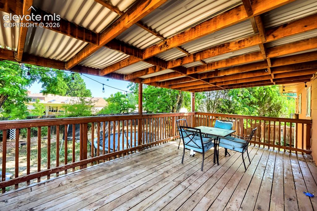 Image 11 of 17: Expansive outdoor deck featuring wood-finish flooring, a robust wooden rail