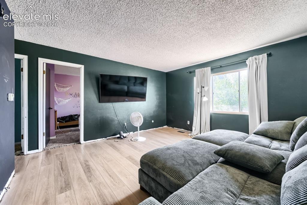 Image 3 of 17: Living space featuring light wood-finish flooring, a large window with whit