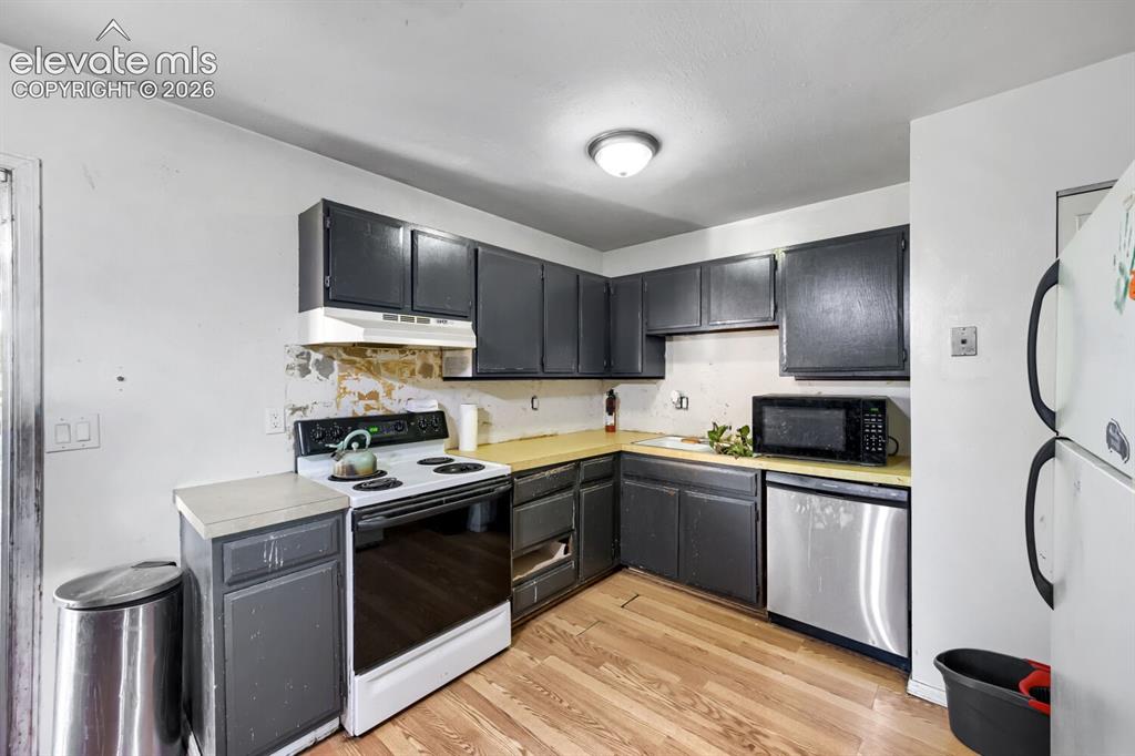Image 5 of 17: Kitchen featuring wood-finish flooring and dark-finish cabinetry
