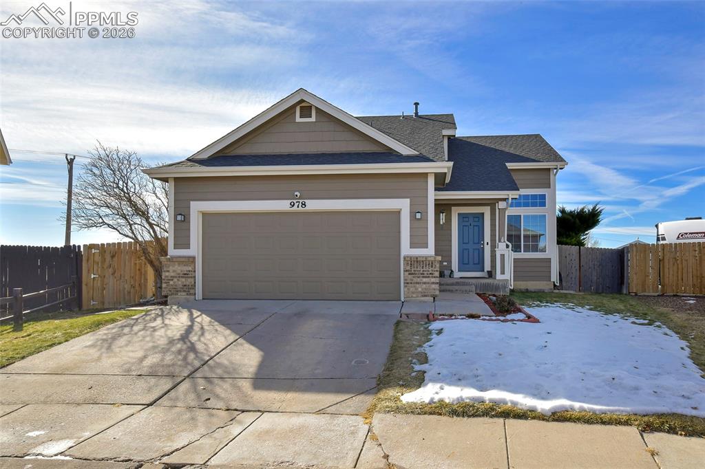 Caption: View of front of property featuring driveway, an attached garage, and a shingled roof