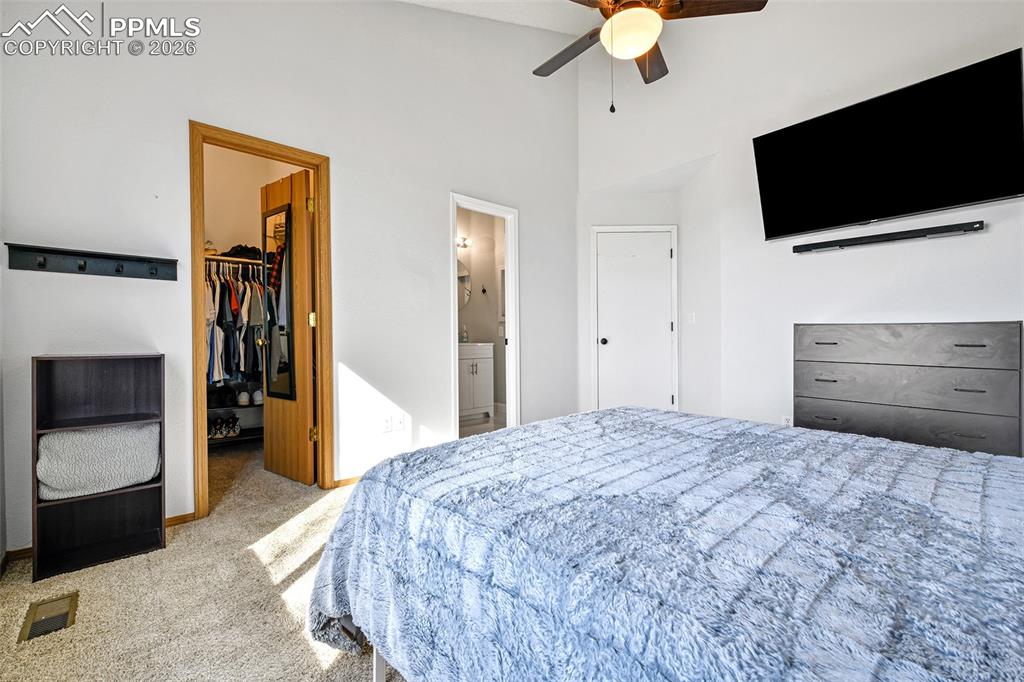 Image 10 of 27: Carpeted bedroom featuring a walk in closet, ceiling fan, a towering ceilin
