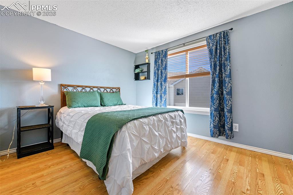 Image 15 of 27: Bedroom featuring light wood-type flooring and a textured ceiling