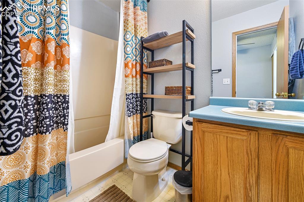 Image 16 of 27: Bathroom with shower / bath combination with curtain, vanity, light floors,