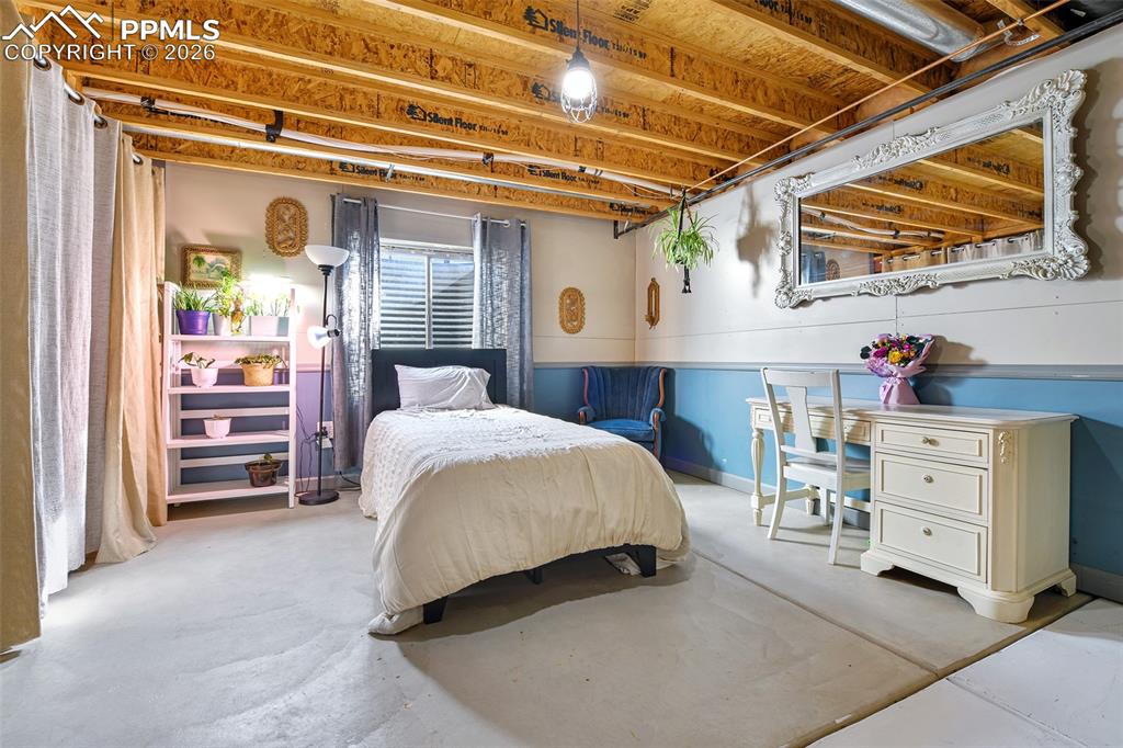 Image 17 of 27: Bedroom with concrete flooring