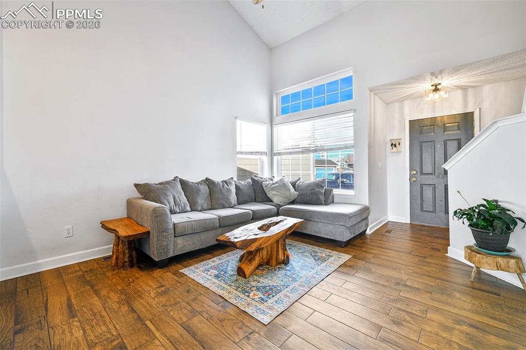 Image 2 of 27: Living room featuring high vaulted ceiling and hardwood / wood-style floori