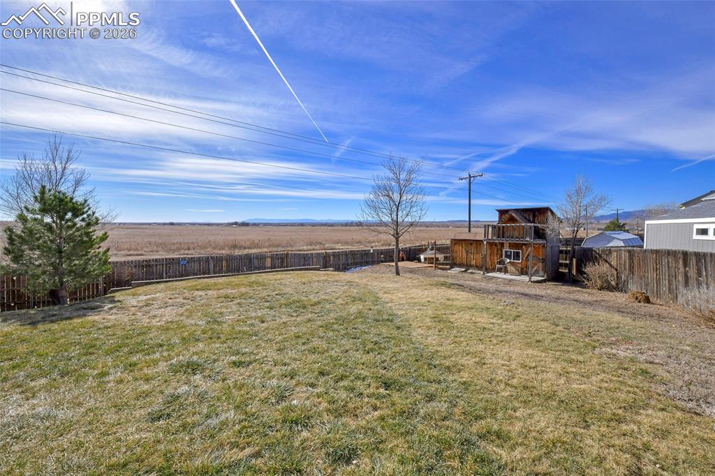 Image 23 of 27: Fenced backyard with an outdoor structure