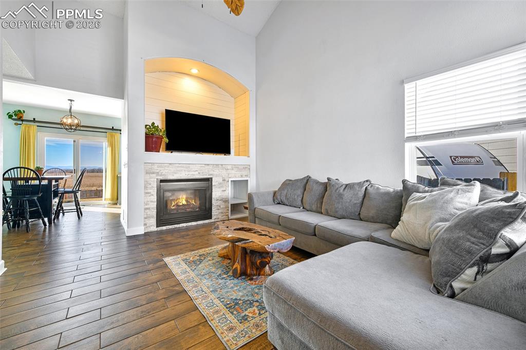Image 3 of 27: Living area featuring dark wood finished floors, high vaulted ceiling, and