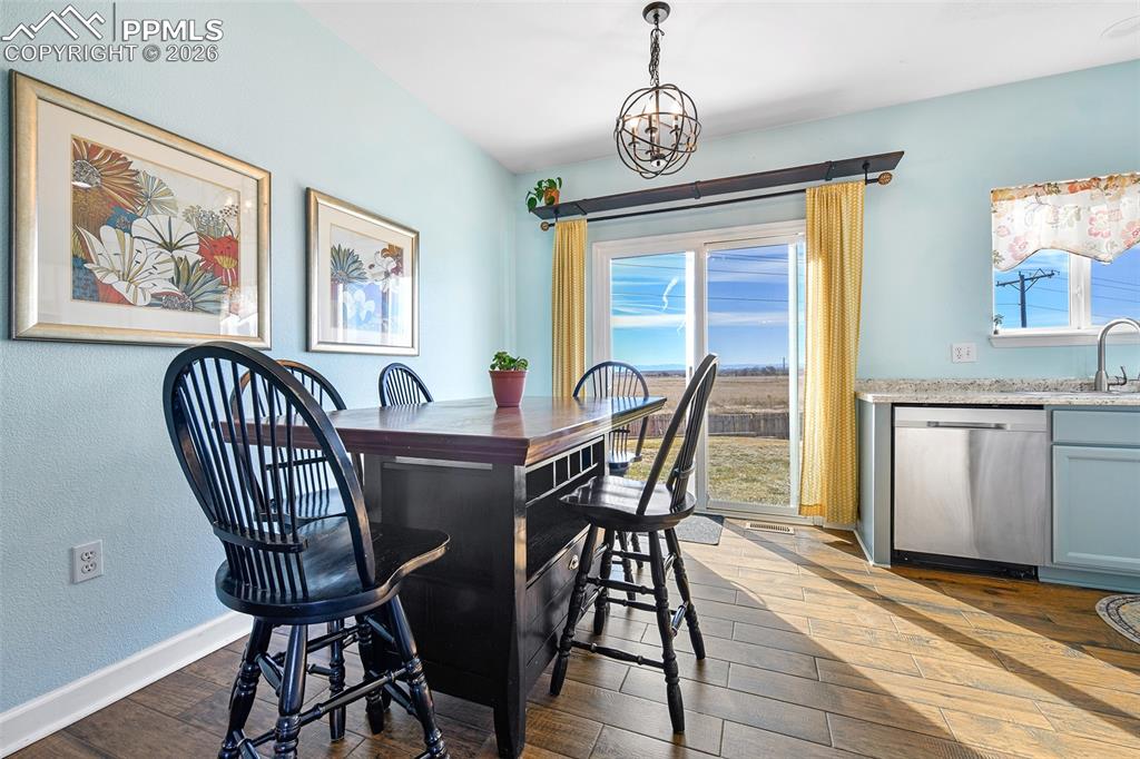 Image 7 of 27: Dining space featuring dark wood finished floors and a textured wall