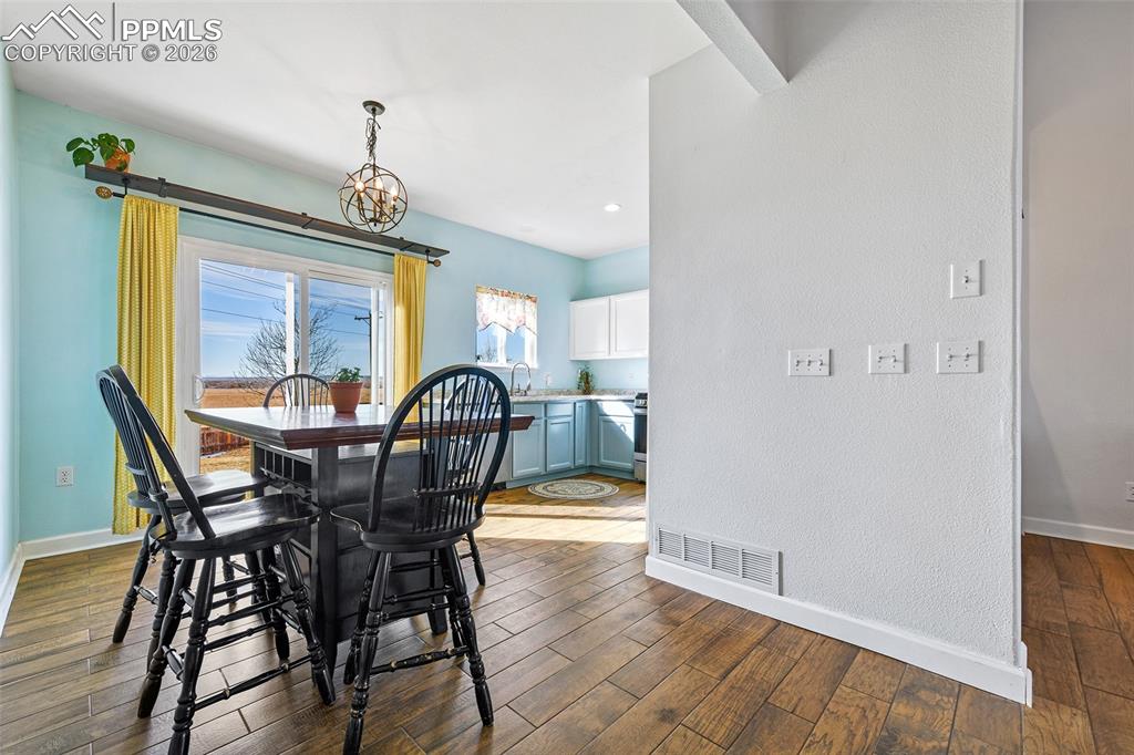 Image 8 of 27: Dining area with dark wood finished floors and recessed lighting